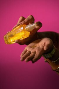 Hand holding a bottle of yellow Argan Oil hair , one of the best hair care products to treat dry hair.